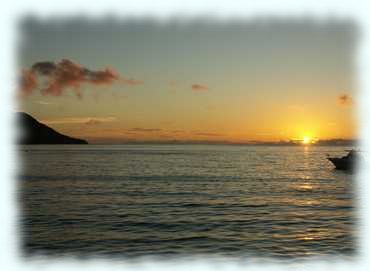 Sonnenuntergang in der Baie de Beau Vallon. Die Insel Silhoutte liegt in Wolken
