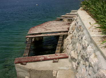 zerstörter Holzsteg am Meer