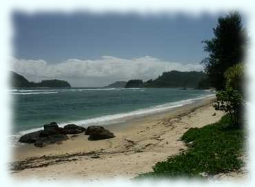 Blick von Port Glaude Richtung Norden, mit schönem Sandstrand im Vordergrund und der Île Thérèse im Hintergrund