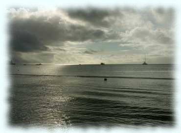 Düsterer Blick aus der Bucht Anse á la Mouche mit dunklen Wolken am Himmel