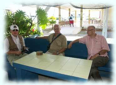 Erwin, Attila und Otto warten sitzend bei einem Tisch