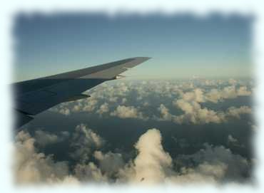 Flügel des Flugzeuges und sonnenbeschienene Wolkendecke