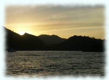 Praslin gen Westen photographiert mit orangem Himmel und Wolken vom Sonnenuntergang