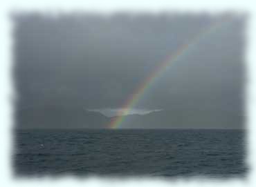 Blick Richtung Praslin mit einem Regenbogen vor grauem Himmel