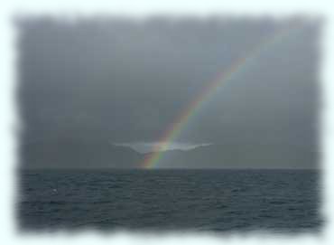 Blick Richtung Praslin mit einem Regenbogen vor grauem Himmel