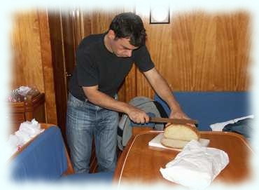 Christian schneidet das Brot für das Frühstück