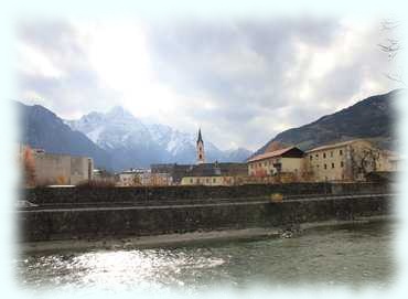 Blick auf das Stadtzentrum von Lienz und die dahinterliegenden schneebedeckten Lienzer Dolomiten vom anderen Iselufer aus