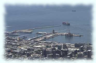 Das Zentrum von Kapstadt mit dem Hafen aus dem ein Containerschiff ausläuft