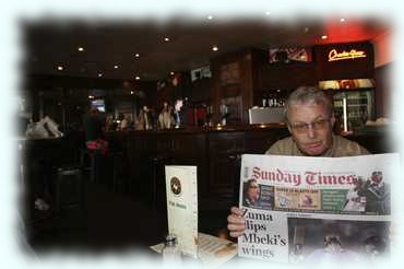 Attila mit einer lokalen Zeitung im Pub des Flughafens von Johannesburg