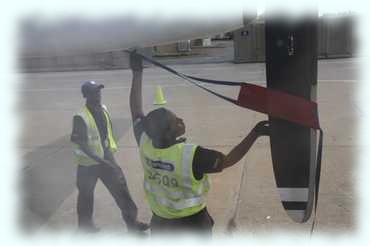 Ein Flughafenangestellter entfernt die Sicherung des Propellers des Flugzeugs