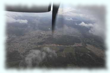 Blick auf eine Kleinstadt aus dem fliegenden Flugzeug