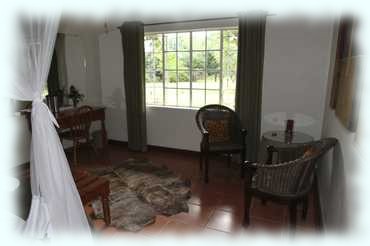 Das Zimmer und das Fenster mit dem Blick in den Garten der Seringa Lodge