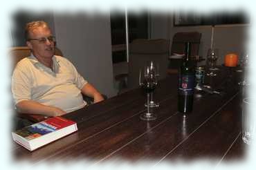 Attila sitzt am Tisch mit einem Glas Wein