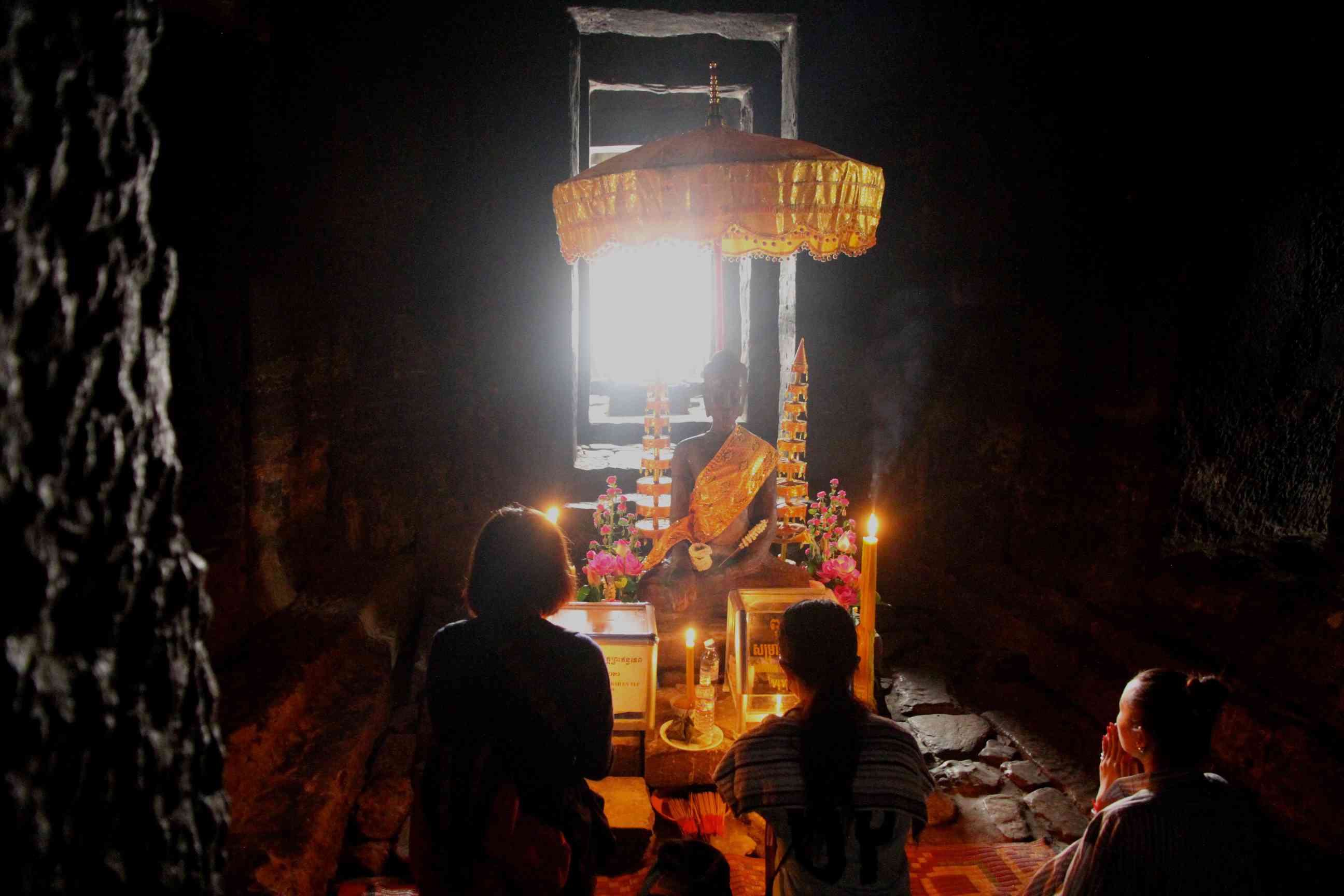 Betende vor einem Buddha unter der Kuppel im Inneren des Bayon