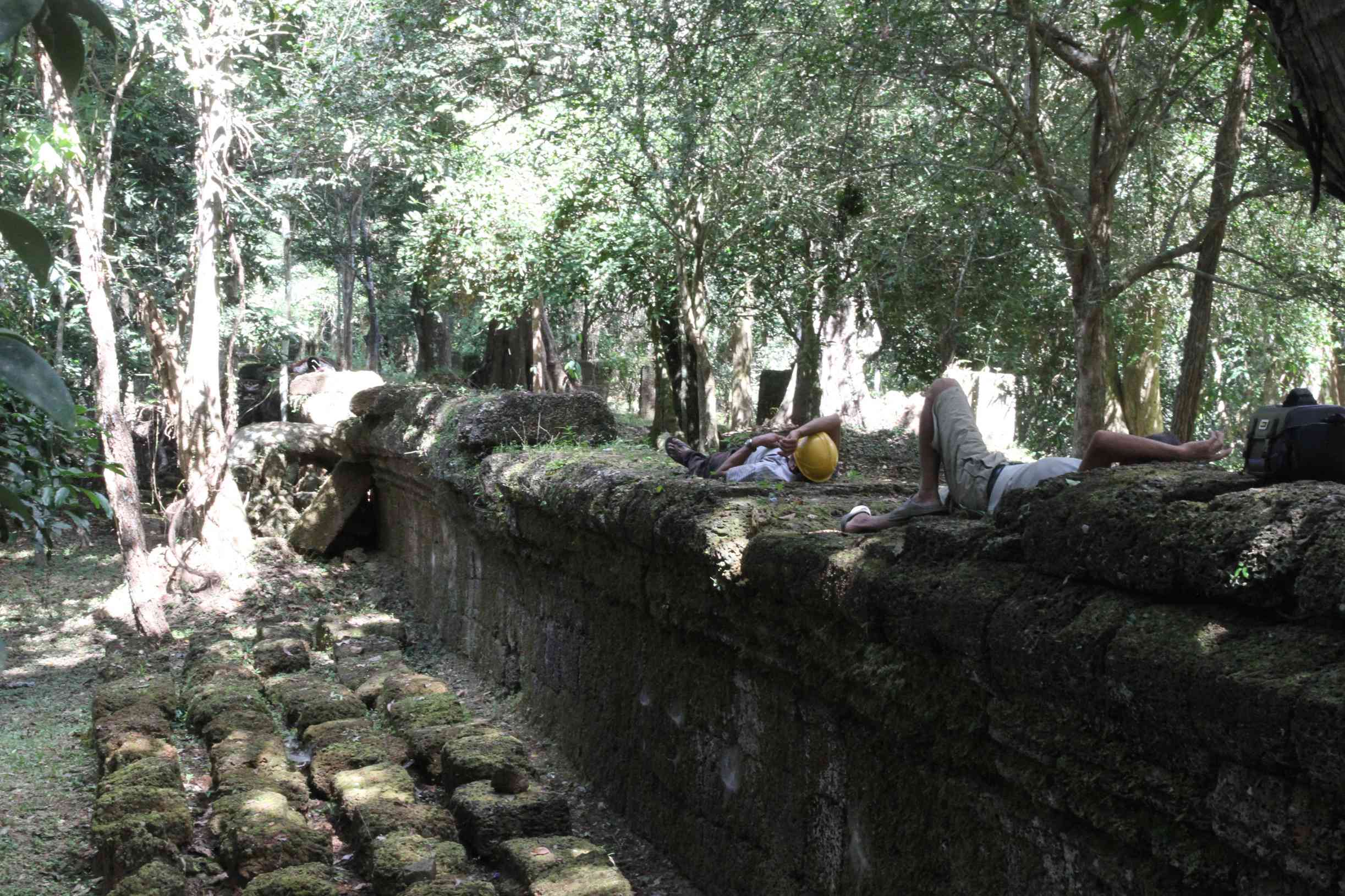 Arbeiter liegen auf der Mauer des Ta Prohm und ruhen sich aus