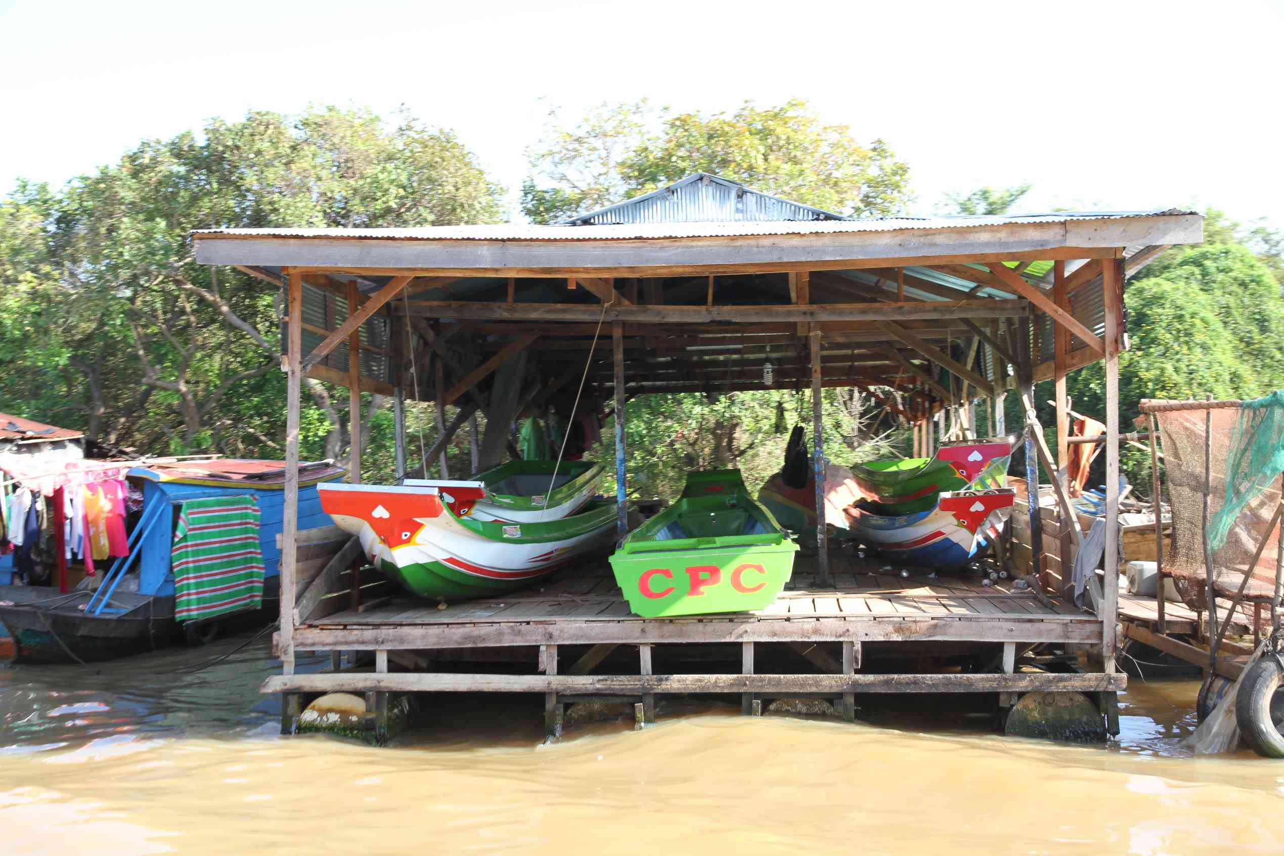 Schwimmende Bootswerft auf dem Tonle Sap See mit gestapelten Holzbooten