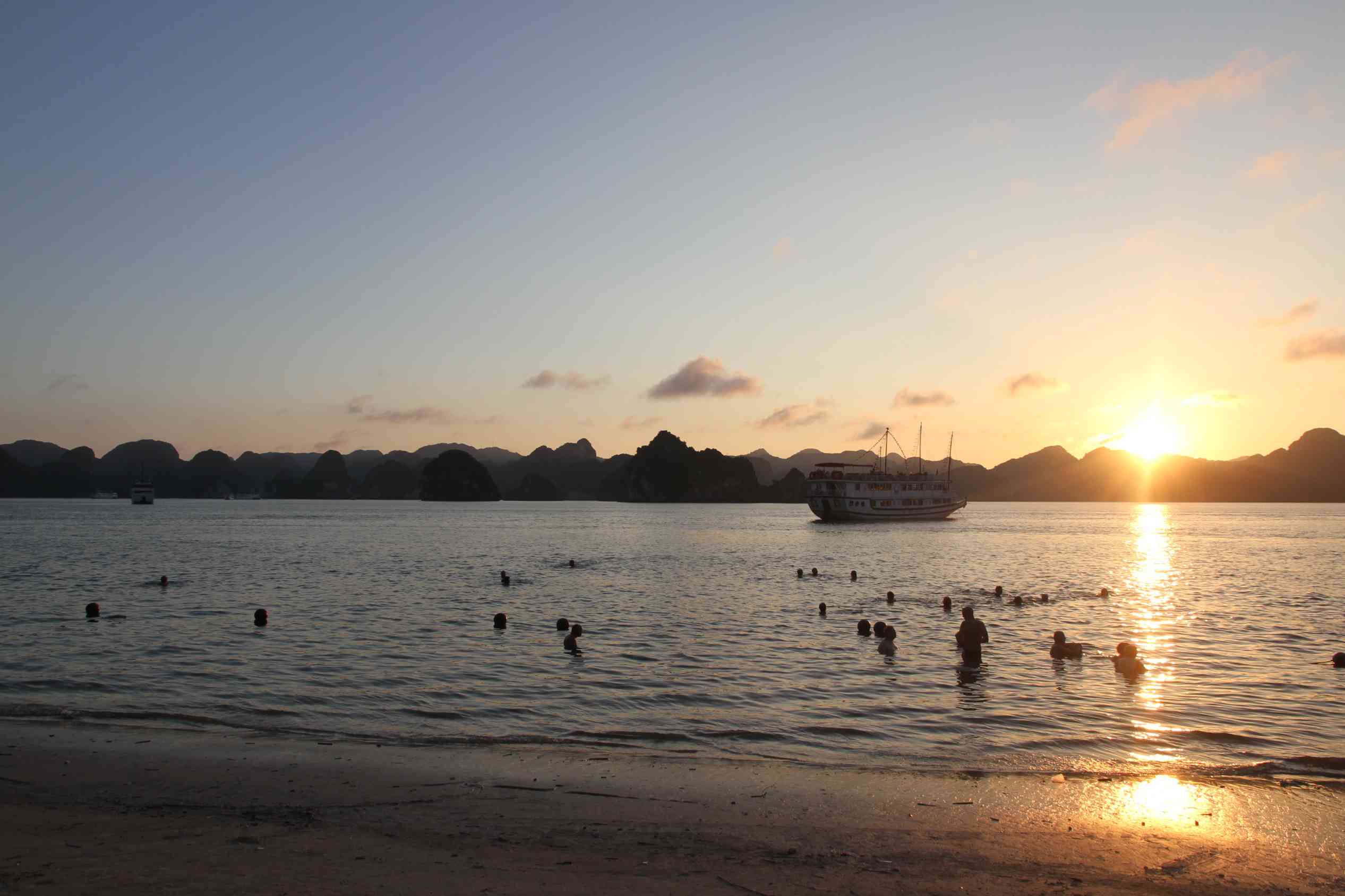 Sonnenuntergang vor einem Sandstrand auf einer der Inseln in der Halong-Bucht