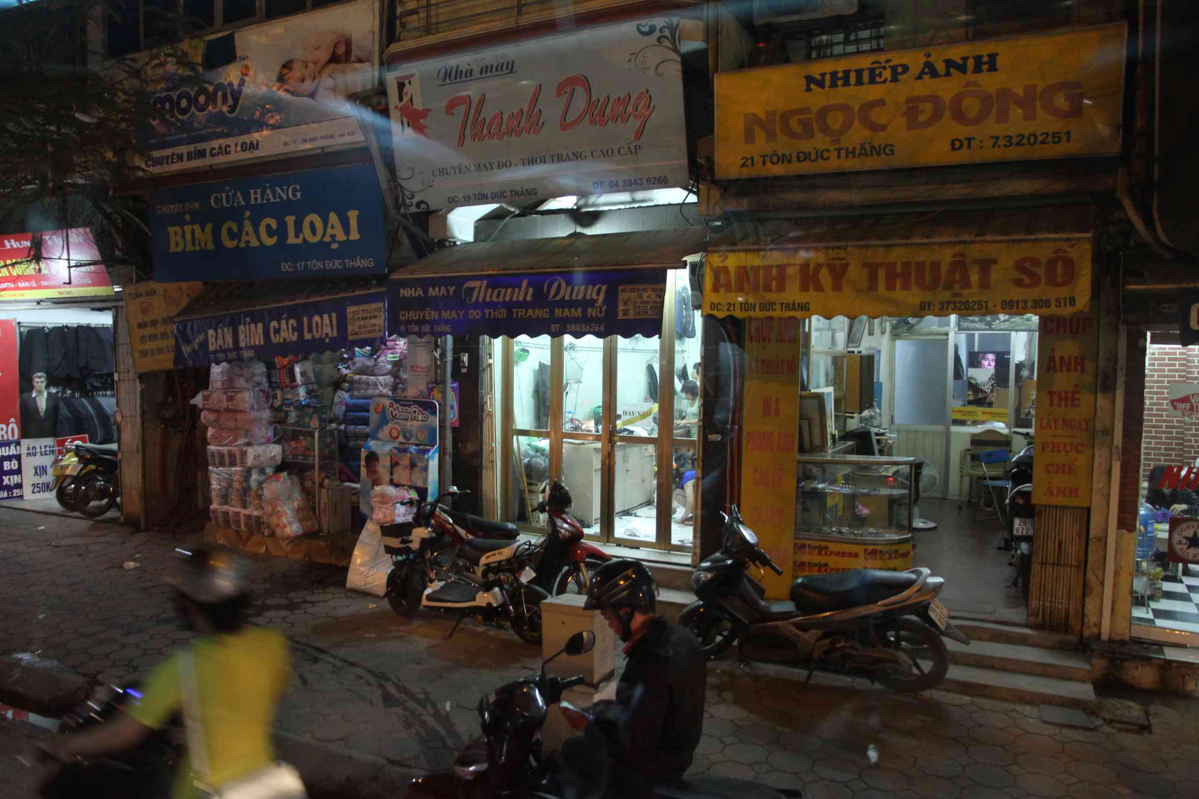 Strassenszene mit Geschäften am Abend in Hanoi
