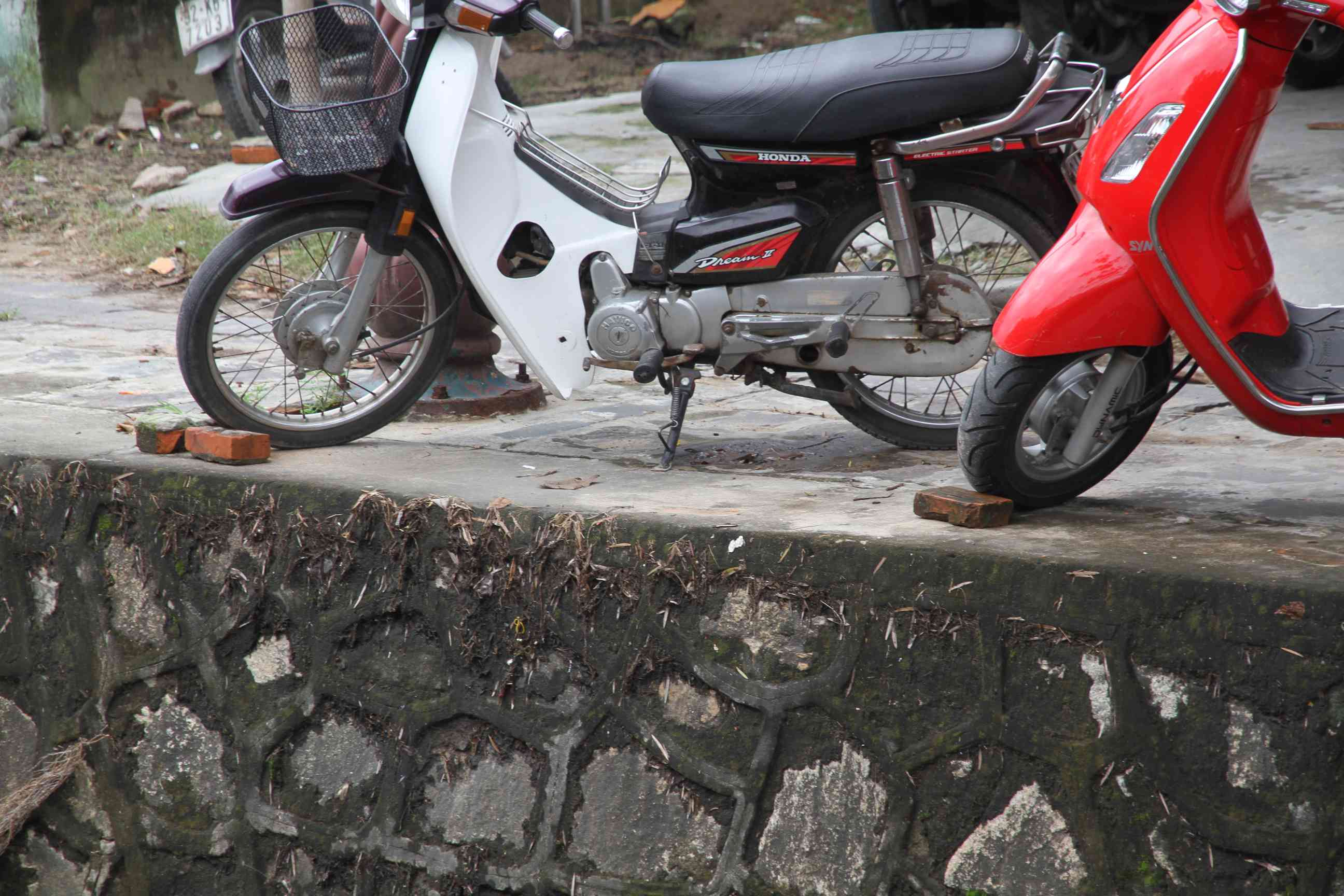 Detailaufnahme von einem Mopedparkplatz am Kanal in der Altstadt von Hoi An